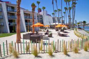 长滩玛雅酒店 - 希尔顿逸林酒店的海滩上设有椅子和遮阳伞,棕榈树