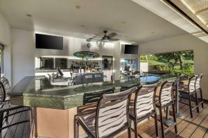 科洛阿Hilton Vacation Club The Point at Poipu Kauai的厨房以及带椅子酒吧的客厅。