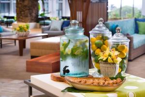 卡帕阿考艾岛怀卢阿湾希尔顿花园酒店，HI的一张桌子,上面放着两瓶玻璃瓶和一碗鲜花