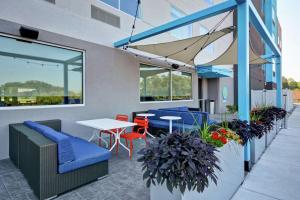 DenverTru By Hilton Denver, PA的庭院设有蓝色的桌椅和窗户。