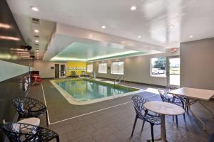 DenverTru By Hilton Denver, PA的游泳池位于酒店客房内,配有椅子和桌子