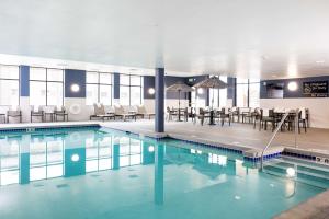 拉克罗斯拉克罗斯市中心汉普顿套房酒店的大楼内带桌椅的游泳池