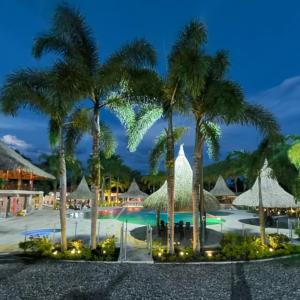 比亚维森西奥HOTEL CAMPESTRE Palma的一个带棕榈树和遮阳伞的游泳池的度假酒店