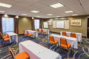 默塞德默塞德希尔顿恒庭套房酒店的一间会议室,配有白色的桌子和橙色的椅子