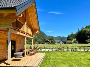 格吕瑙Das Grünhaus - Dein Chalet in Grünau im Almtal的小屋设有1个带桌子和长凳的甲板