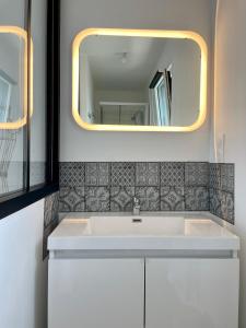 PorsmilinPENTY的浴室设有白色水槽和镜子