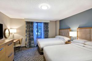 奥兰多Embassy Suites by Hilton Orlando Downtown的酒店客房设有两张床和电视。