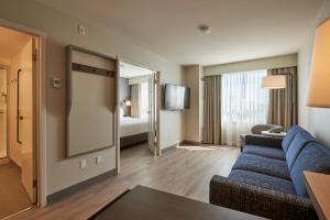 渥太华Holiday Inn & Suites Ottawa Kanata, an IHG Hotel的一间位于酒店客房内的带蓝色沙发的客厅