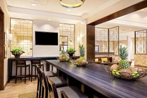 奥兰多奥兰多/市中心南医疗中心汉普顿套房酒店 的用餐室配有长桌、椅子和电视