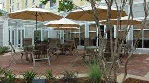 梅里迪恩梅里丹希尔顿花园旅馆的户外庭院配有桌椅和遮阳伞。