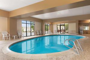 贝德福德Hampton Inn & Suites by Hilton Manchester Bedford的酒店的大型游泳池配有桌椅