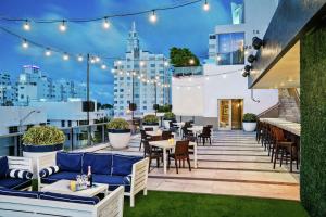 迈阿密海滩Gale South Beach, Curio Collection By Hilton的屋顶露台配有桌椅和灯光