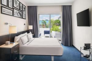 迈阿密海滩Gale South Beach, Curio Collection By Hilton的酒店客房,配有床和电视