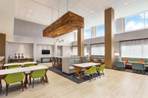 肯代尔Hampton Inn & Suites Miami, Kendall, Executive Airport的一个带桌椅的办公大厅和一间自助餐厅