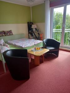 柏林Hübsches Zimmer nahe BER的配有一张床和一张桌子及椅子的房间