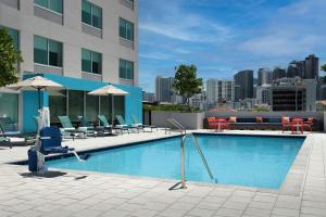 迈阿密Tru By Hilton Miami West Brickell的一座带桌椅的游泳池以及一座建筑