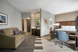 堪萨斯城Hampton Inn Suites Kansas City Downtown Crossroads的酒店客房配有一张床、一张书桌和一张沙发。
