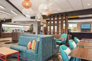 沃科夏Tru By Hilton Milwaukee Brookfield的一间配备有蓝色沙发和桌子的等候室