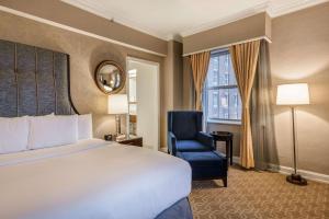 密尔沃基密尔沃基市中心希尔顿酒店的酒店的客房 - 带一张床、椅子和窗户