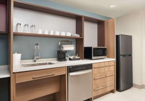 墨尔本Home2 Suites By Hilton Palm Bay I 95的厨房配有水槽和冰箱