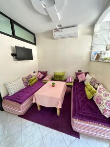 阿加迪尔Sidi Youssef Agadir的客厅配有紫色沙发和桌子