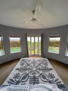 拉罗汤加Iro Luxury Retreat的一间卧室配有一张带吊扇和窗户的床。