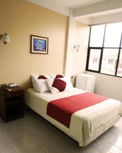 圣克鲁斯Hotel Plaza Center的一间卧室配有一张带红色毯子的大床