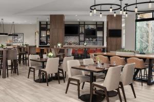 明尼阿波利斯明尼阿波利斯市区希尔顿花园旅馆的一间带桌椅的餐厅和一间酒吧