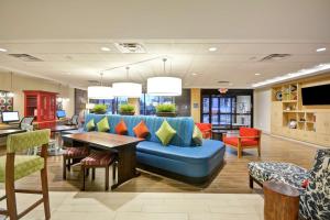 明尼通卡Home2 Suites By Hilton Minneapolis-Eden Prairie的大堂设有蓝色的沙发和桌椅