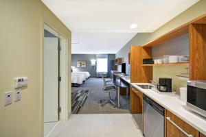 明尼通卡Home2 Suites By Hilton Minneapolis-Eden Prairie的酒店客房设有厨房和一张床