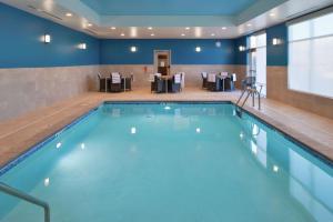莱克维尔Hampton Inn Lakeville Minneapolis, Mn的游泳池位于酒店带桌椅的客房内