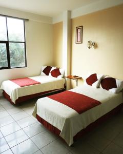 圣克鲁斯Hotel Plaza Center的酒店客房设有两张床和窗户。