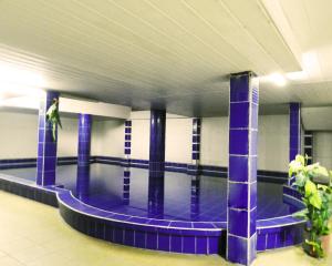 圣克鲁斯Hotel Plaza Center的一座建筑物中的游泳池,旁边是人