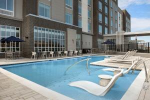 弗洛伦斯Hilton Garden Inn Florence Cincinnati Airport South的一座配有桌椅的酒店游泳池