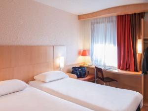 穆兰穆兰宜必思酒店的酒店客房设有两张床、一张书桌和一个窗户。