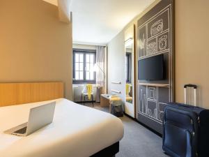 布鲁塞尔宜必思酒店布鲁塞尔大广场的酒店客房,配有一张带笔记本电脑的床