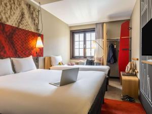 布鲁塞尔宜必思酒店布鲁塞尔大广场的酒店客房设有两张床和一张书桌上的笔记本电脑