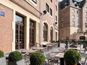 布鲁塞尔宜必思酒店布鲁塞尔大广场的一个带桌椅的户外庭院,并拥有一座建筑