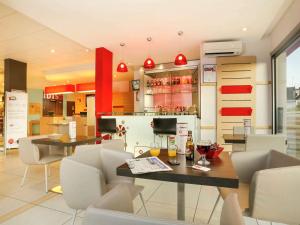 布里夫拉盖亚尔德Ibis Brive Centre的一间带桌椅的餐厅和酒吧