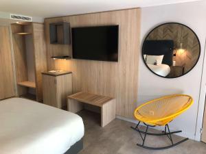 瓦尔邦讷安提比斯索非亚安蒂波利斯美居酒店的一间卧室配有一张床、镜子和椅子