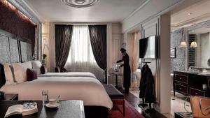 河内河内传奇新都城索菲特酒店的一位妇女站在带大床的卧室