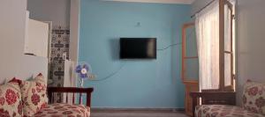 萨菲amine adnane的客厅配有沙发和蓝色墙壁上的电视