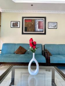 弗朗西斯科德奥雷利亚纳港Hostal R. Williams的客厅设有蓝色的沙发和玫瑰花瓶