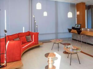 欧里尼奥斯ibis Ourinhos的客厅配有红色沙发和钢琴