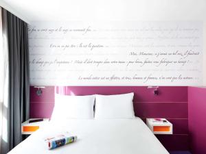 蒙彼利埃蒙彼利埃喜剧中心宜必思尚品酒店的卧室配有一张挂在墙上的写字床