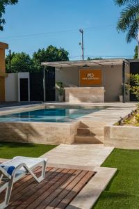 梅里达Hotel MID Project的一个带白色椅子的庭院内的游泳池