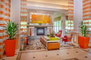 切斯特菲尔德圣路易斯/切斯特菲尔德希尔顿花园酒店的客厅设有壁炉和橙色家具。