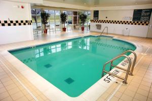 切斯特菲尔德圣路易斯/切斯特菲尔德希尔顿花园酒店的酒店大堂设有大型游泳池及长凳