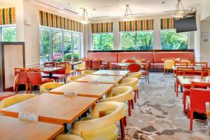 切斯特菲尔德圣路易斯/切斯特菲尔德希尔顿花园酒店的餐厅设有桌椅和窗户。