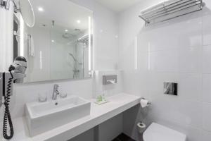 阿姆斯特丹阿姆斯特丹市中心NH酒店的白色的浴室设有水槽和镜子